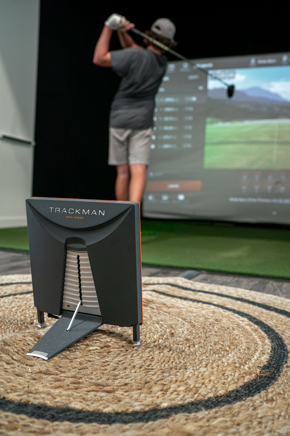 A golfer using our indoor simulators with Trackman technology for golf training.